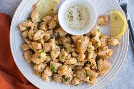 Healthy Garlic Lemon Chicken Bites served golden and juicy, garnished with herbs and lemon slices for a fresh, flavorful low-carb meal option.